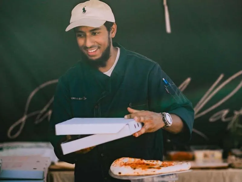 SR Pizza chef serving a fresh pizza at an event